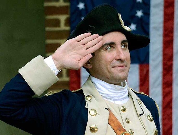 18th century soldier saluting the American Flag Philadelphia Pennsylvania USA