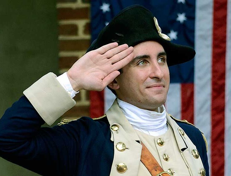 18th century soldier saluting the American Flag Philadelphia Pennsylvania USA