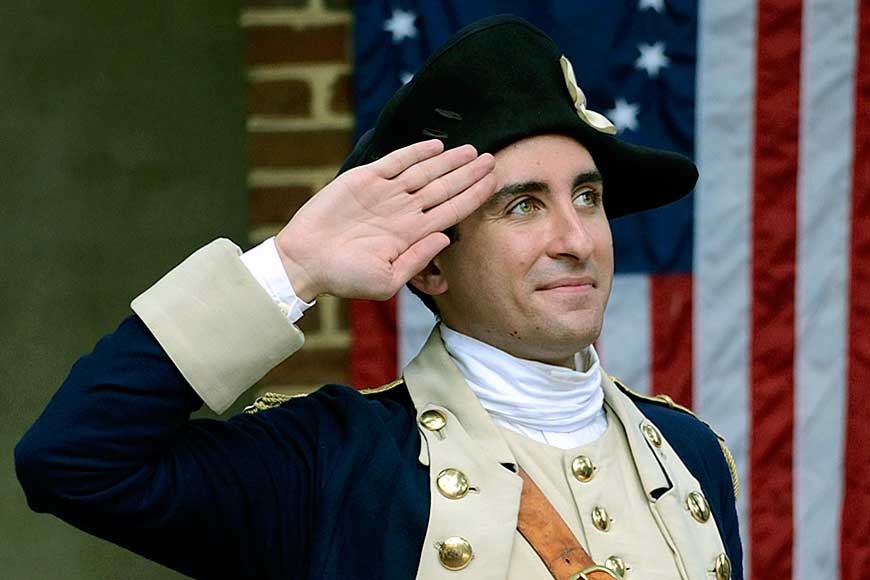 18th century soldier saluting the American Flag Philadelphia Pennsylvania USA