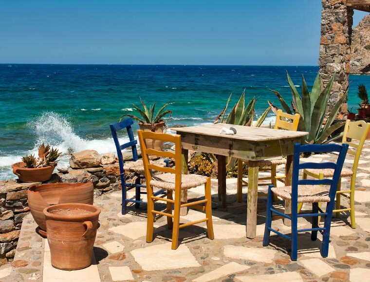 Table and chairs at the water's edge, Mochlos, Crete