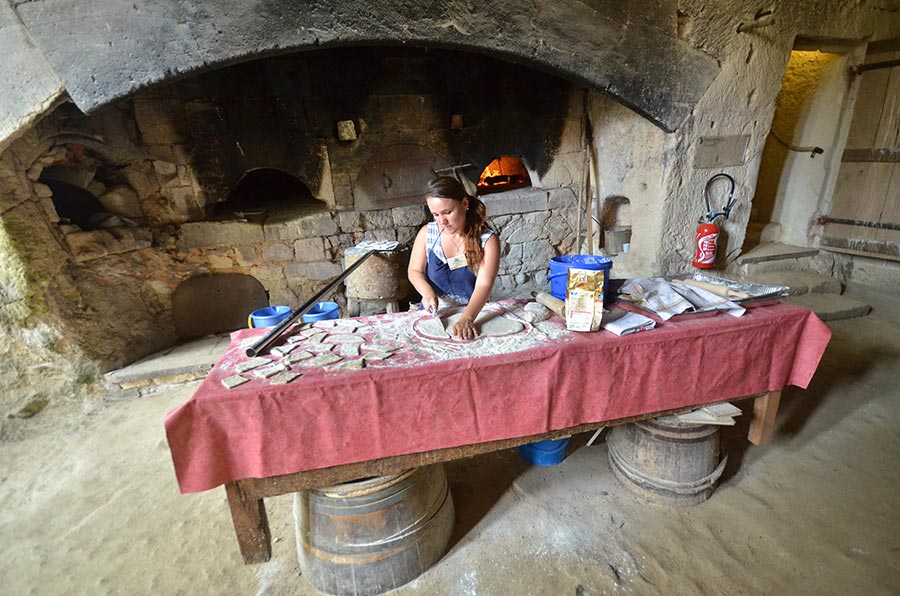 Cook preparing Fouaces on a long table at Château de Brézé, Loire France