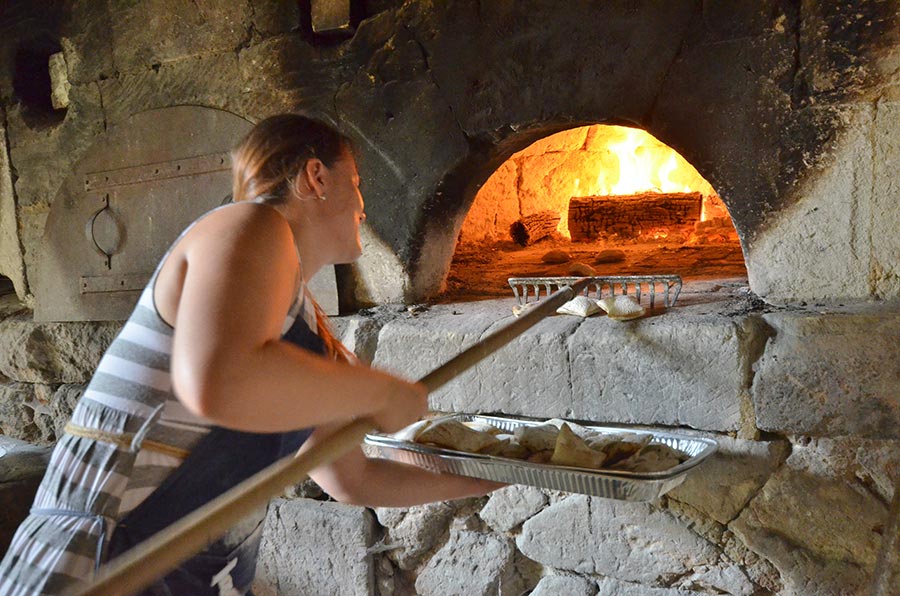 Raking out the Fouaces from the wood fired oven at Château de Brézé, Loire France