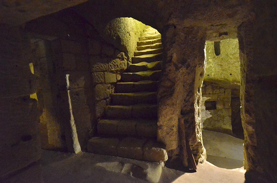 Walking through the network of underground tunnels, galleries, and rooms carved into limestone at Château de Brézé