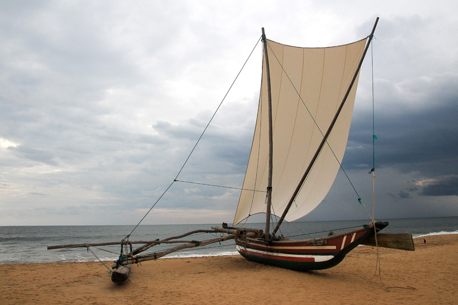 Traditional Sri Lankan fishing boat - An Oruwa outrigger, on the beach at Negombo - Sri Lanka