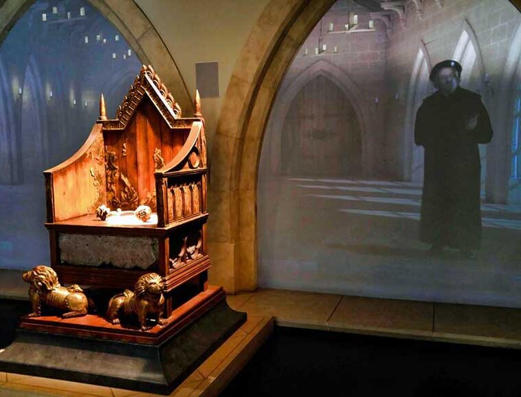 Inside King Richard III Visitor Centre showing wooden throne with video backdrop