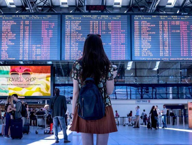 Person looking at airport departure and arrival boards