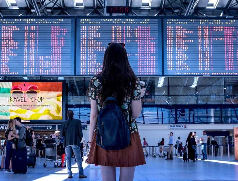 Person looking at airport departure and arrival boards