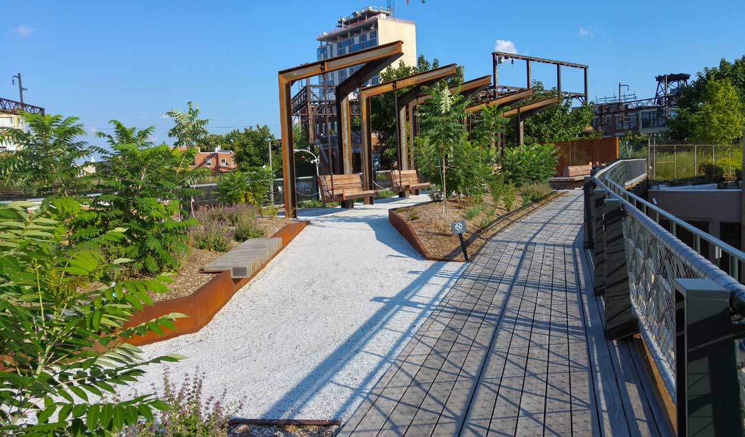 Green space with plants, footpath and bench seats at Reading Railroad viaduct Philadelphia USA
