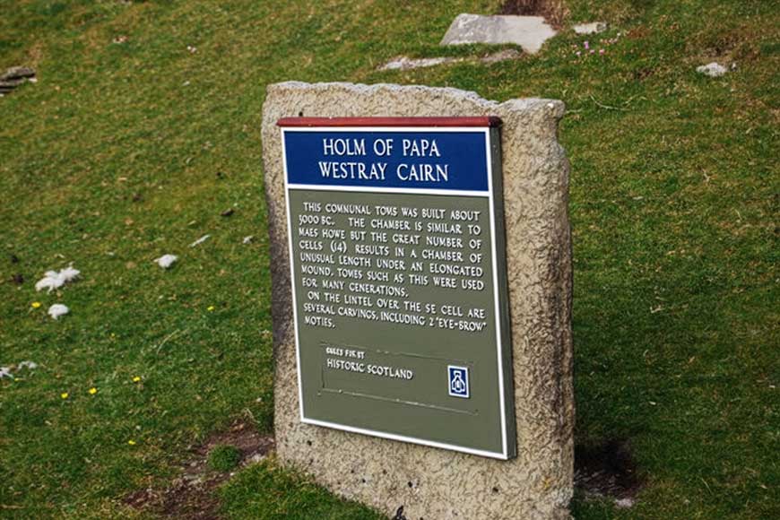 Informational sign for the Holm of Papa Westray Cairn, a large and well-preserved Neolithic chambered tomb located on the uninhabited island of Holm of Papa Westray in Orkney, Scotland