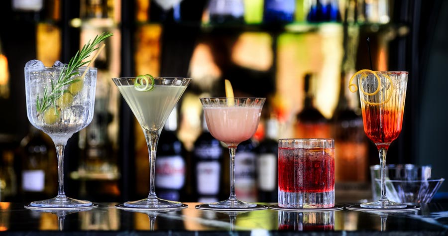 Cocktails lined up on a bar