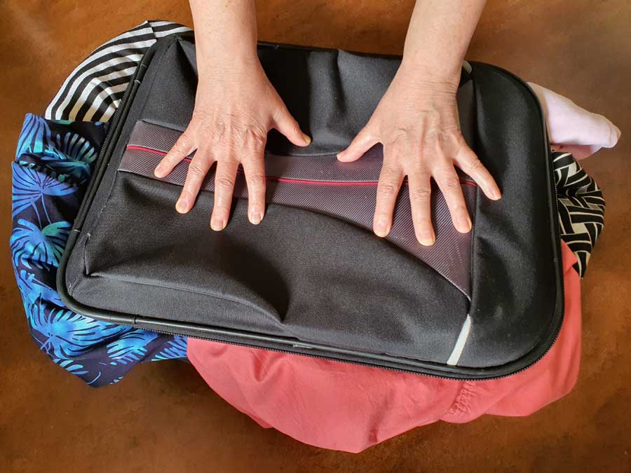 Squashing a suitcase after packing too many clothes