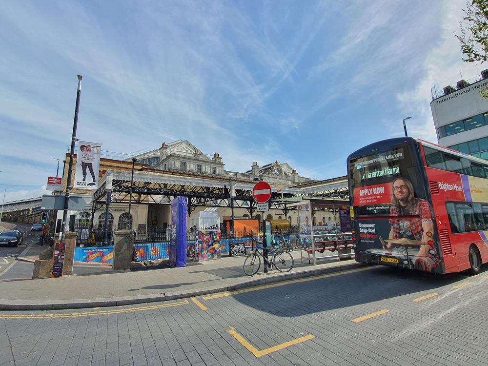 Exterior of Brighton raailway station showing bus stop, bus and blue sky 
