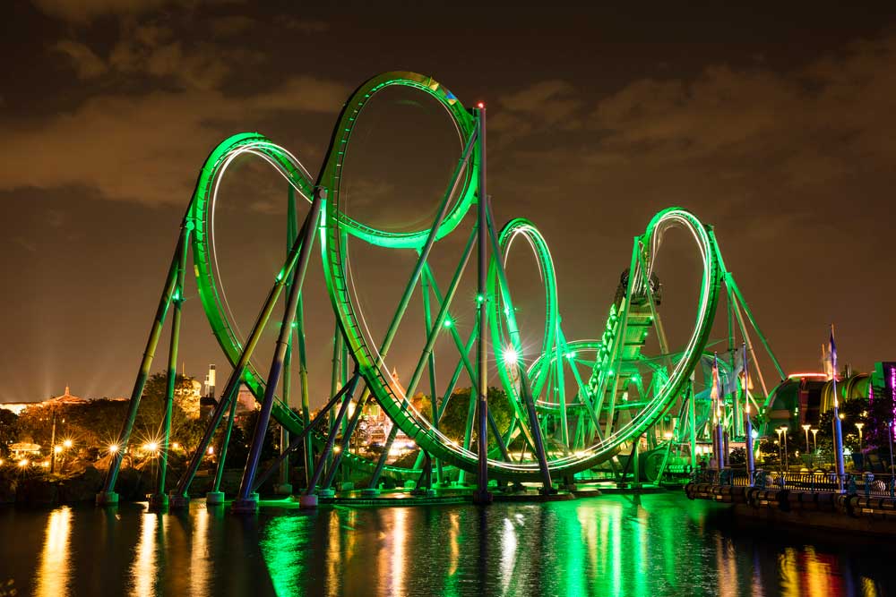 The Incredible Hulk Coaster Universal Resorts Orlando lit up with green light at night