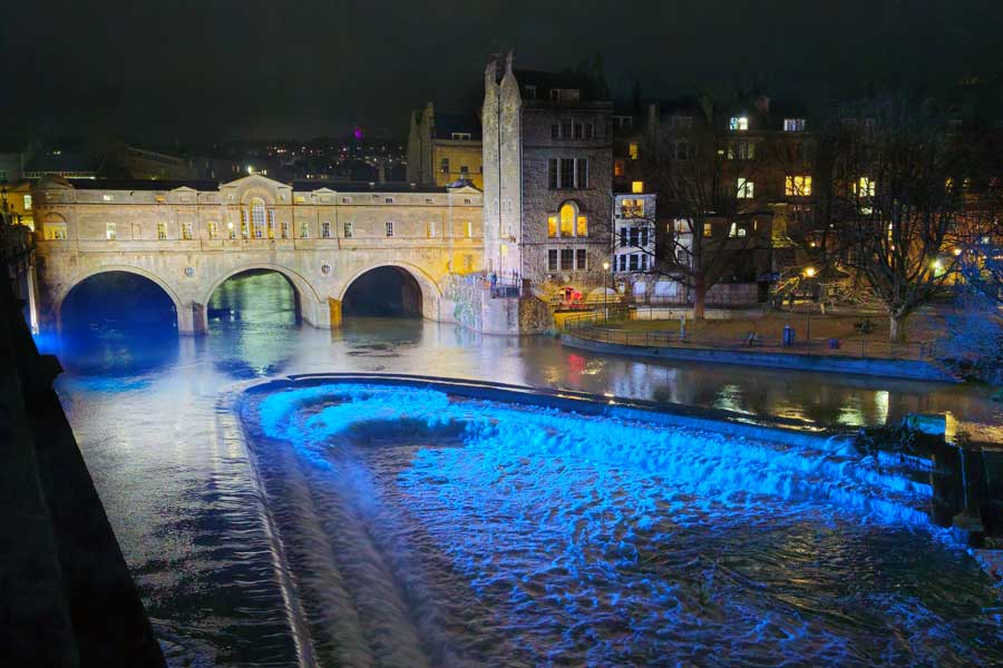 Pulteney Bridge and weir in Bath, UK lit up at night