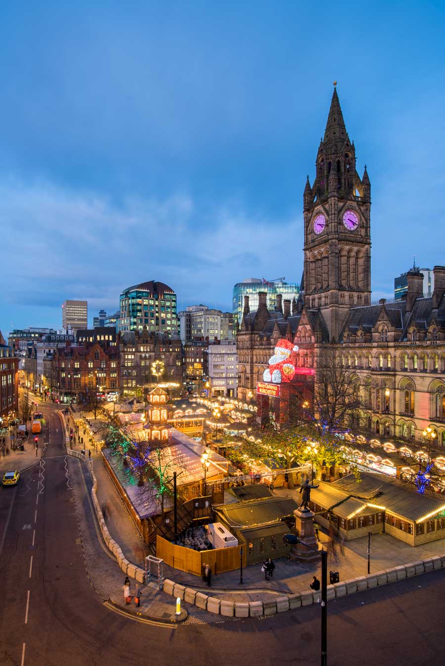 Aerial view at dusk of Christmas market stalls at Albert Square Manchester UK