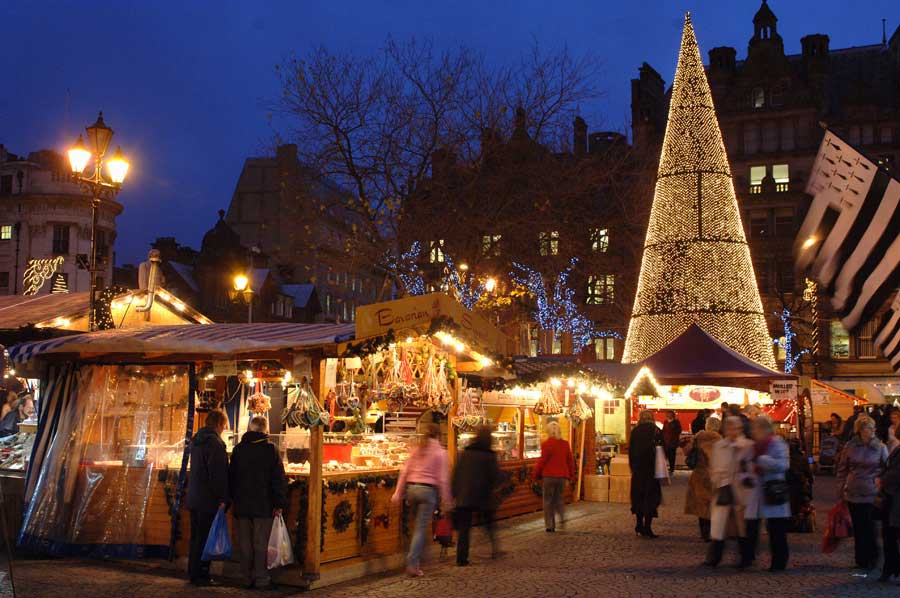 Christmas Market stalls at dusk in Albert Square Manchester UK