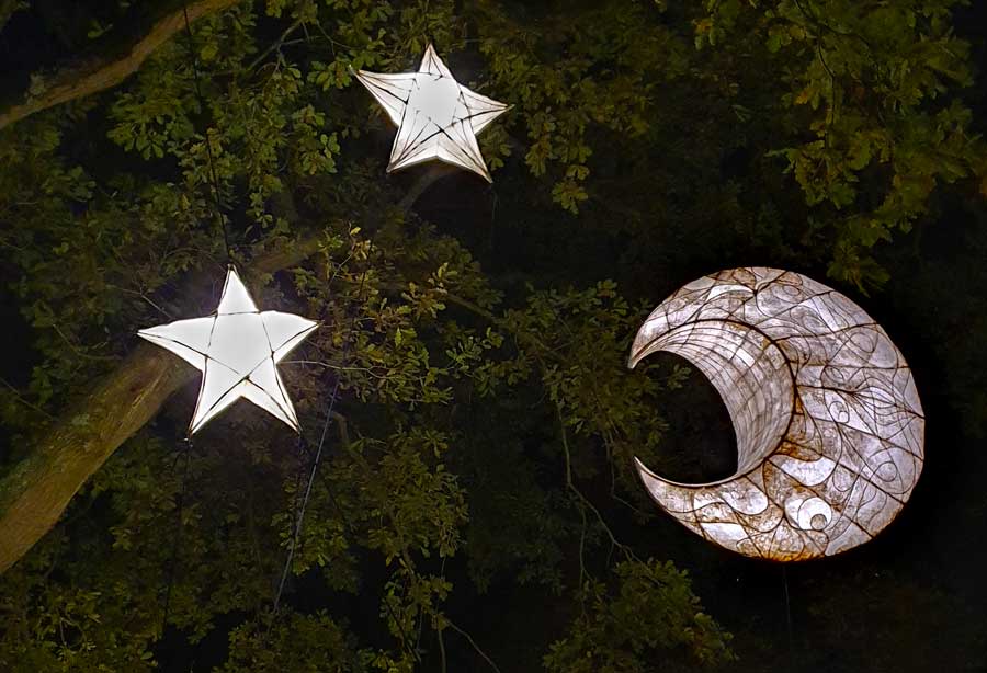 Crescent moon and star lanterns hanging in tree at Glow Wild Wakehurst West Sussex