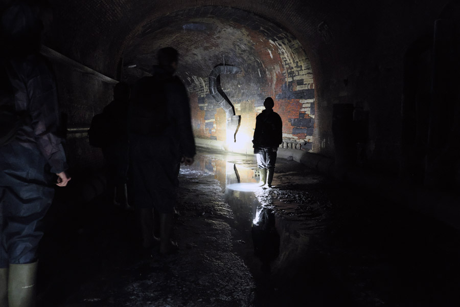 Tourist group following the guide in the historic former canals and sewers under Antwerp Belgium