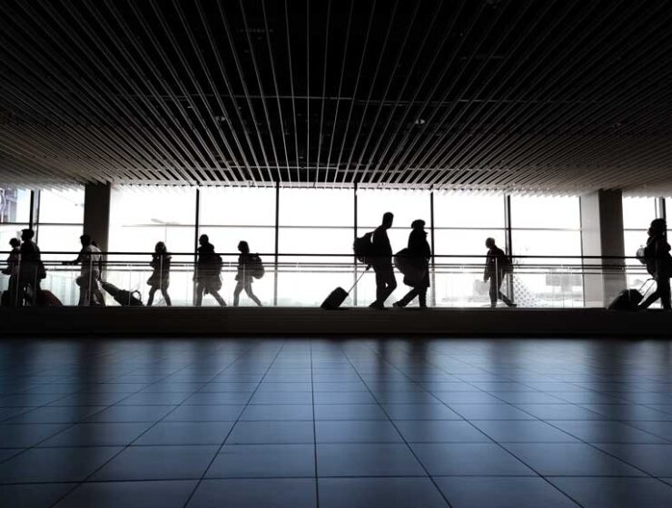 People in silhouette walking in airport terminal