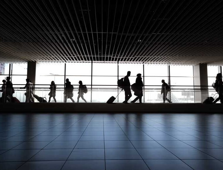 People in silhouette walking in airport terminal