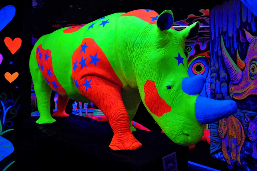 Large model rhinoceros painted in neon red and green with blue neon stars at Globalls Brighton Marina East Sussex