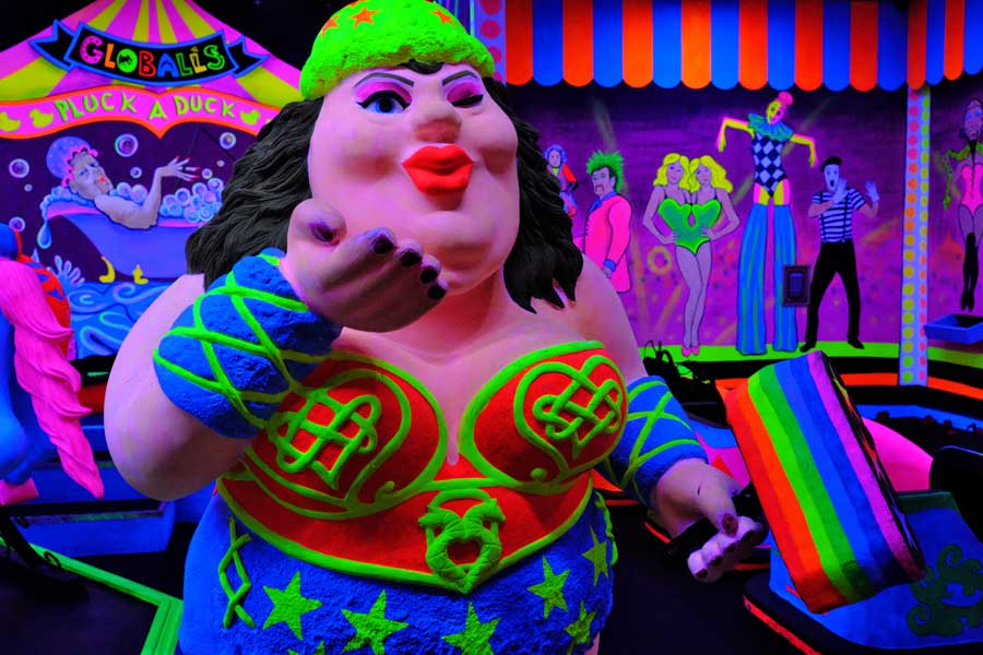 The neon painted strong woman model in Carnival Games at Globalls Brighton Marinal