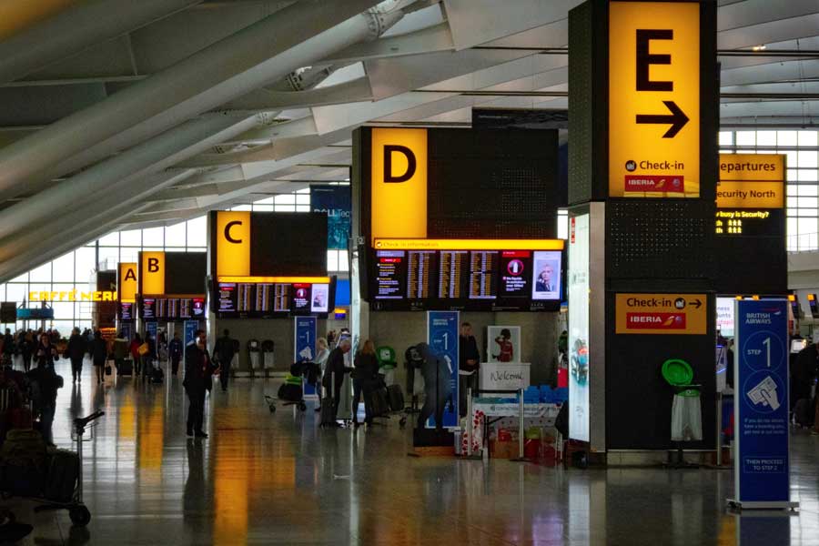 Yellow check in boards and flight departure information in terminal 5 Heathrow Airport UK