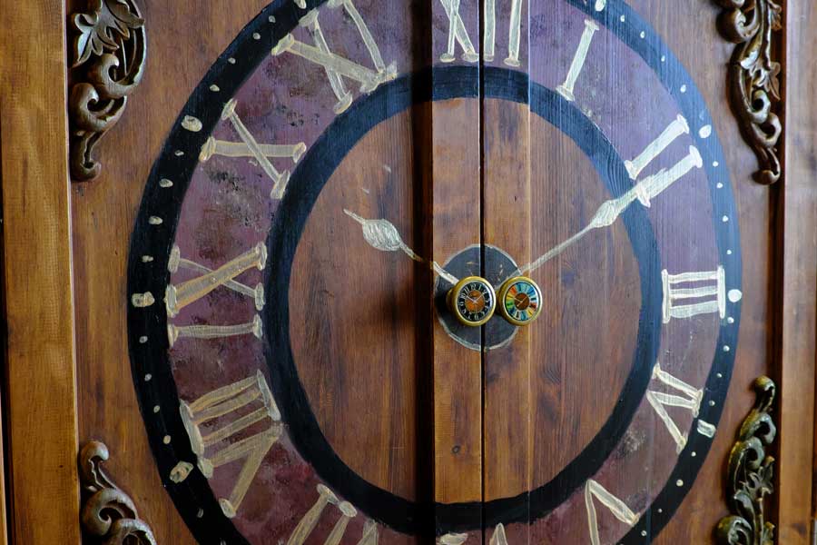 Clock face decoration and clock face doorknobs on cupboard doors at Looking Glass Cottage, Brighton, UK