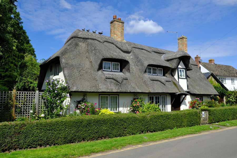 Thatched house with thatched duck finials in Houghton village Cambridgeshire