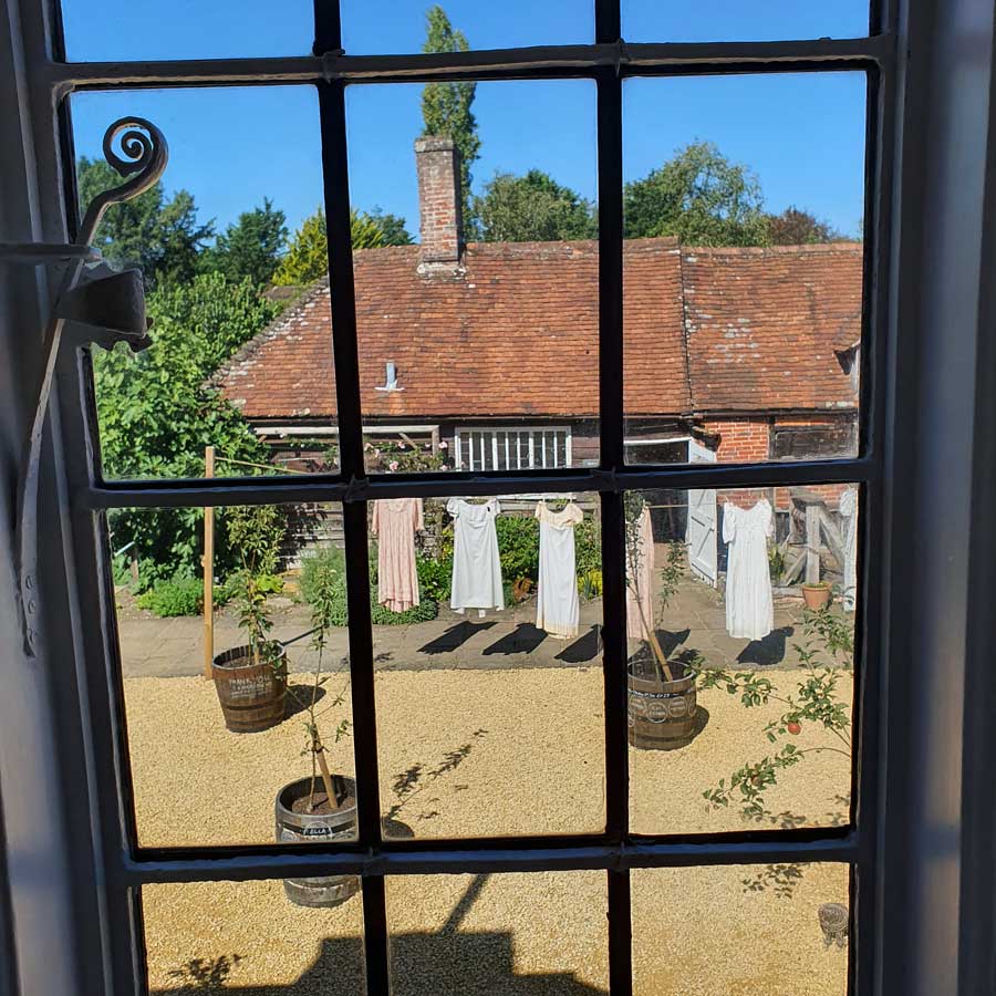 View of the courtyard and washing on the line from the bedroom window at Jane Austen House in Chawton, Hampshire, UK