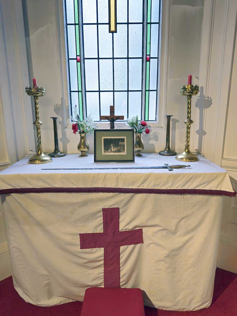 Altar in the Knights Templar chapel in the Masonic Hall Bath UK with candlesticks, crucifix, flowers and an unsheathed sword