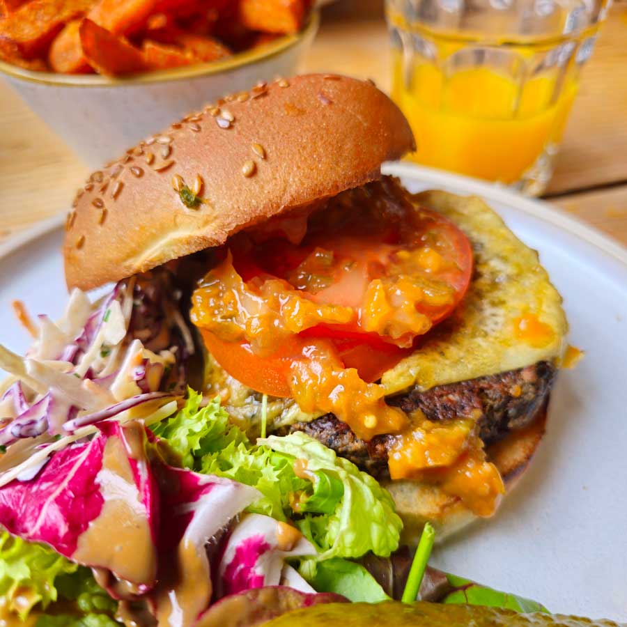 Mushroom burger with vegan cheese and bun, served with salad