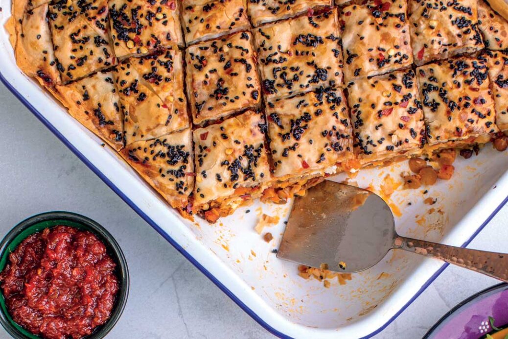 Butternut squash and chickpea Baklava in white serving dish. Recipe from The Garlic Story by Kumud Gandhi