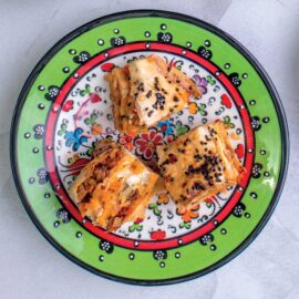 Butternut squash and chickpea Baklava on a multi coloured plate. Recipe from The Garlic Story by Kumud Gandhi