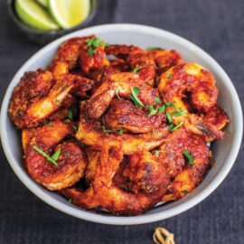 Tiger prawns cooked with Tequila, served in a white bowl. Recipe from The Garlic Story by Kumud Gandhi