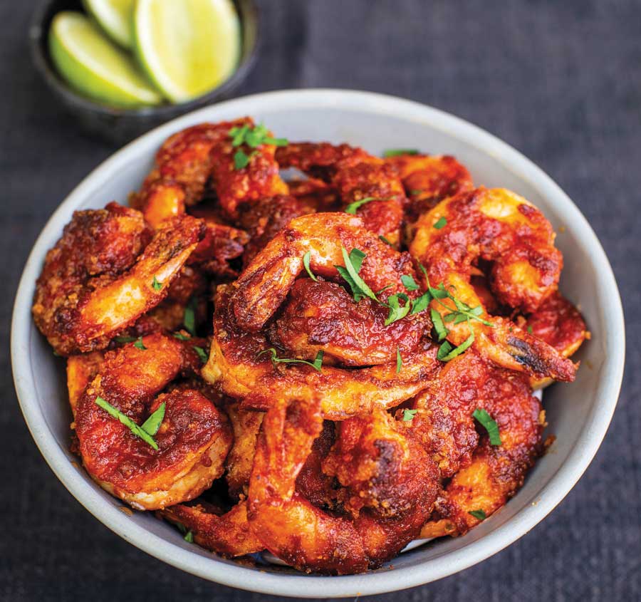 Tiger prawns cooked with Tequila, served in a white bowl. Recipe from The Garlic Story by Kumud Gandhi