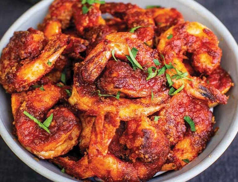 Tiger prawns cooked with Tequila, served in a white bowl. Recipe from The Garlic Story by Kumud Gandhi