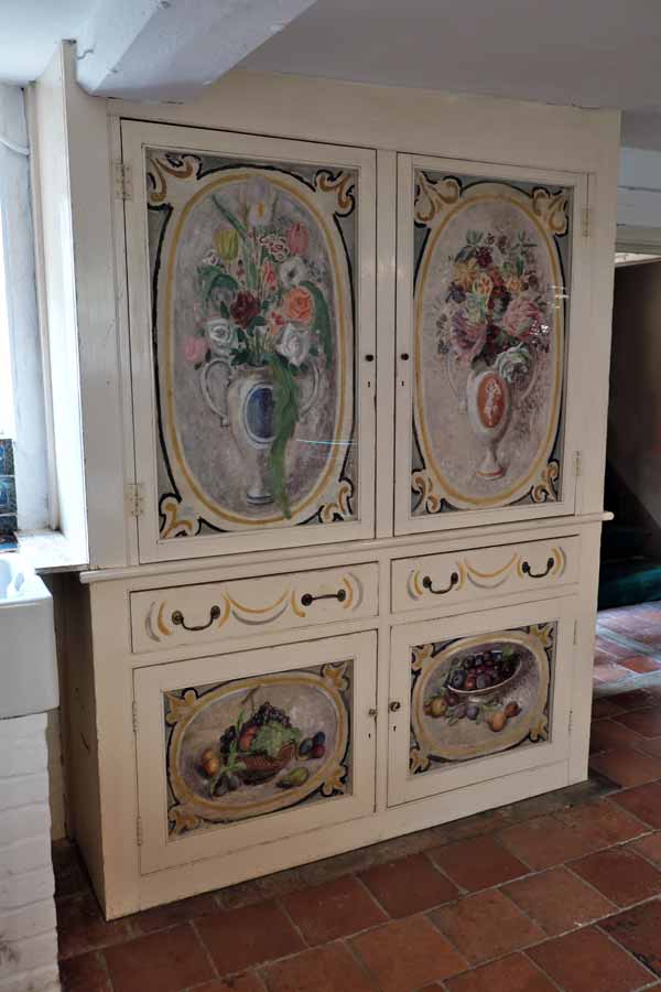 Cupboard decorated with paintings of flowers and fruit in the kitchen of Charleston Farmhouse Firle East Sussex