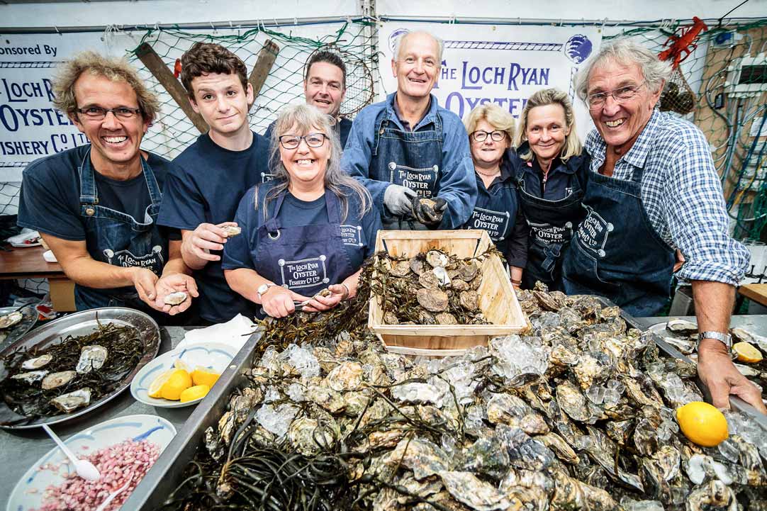 Loch Ryan oyster fishery team standing behind a table full of oysters at Stranraer oyster festival