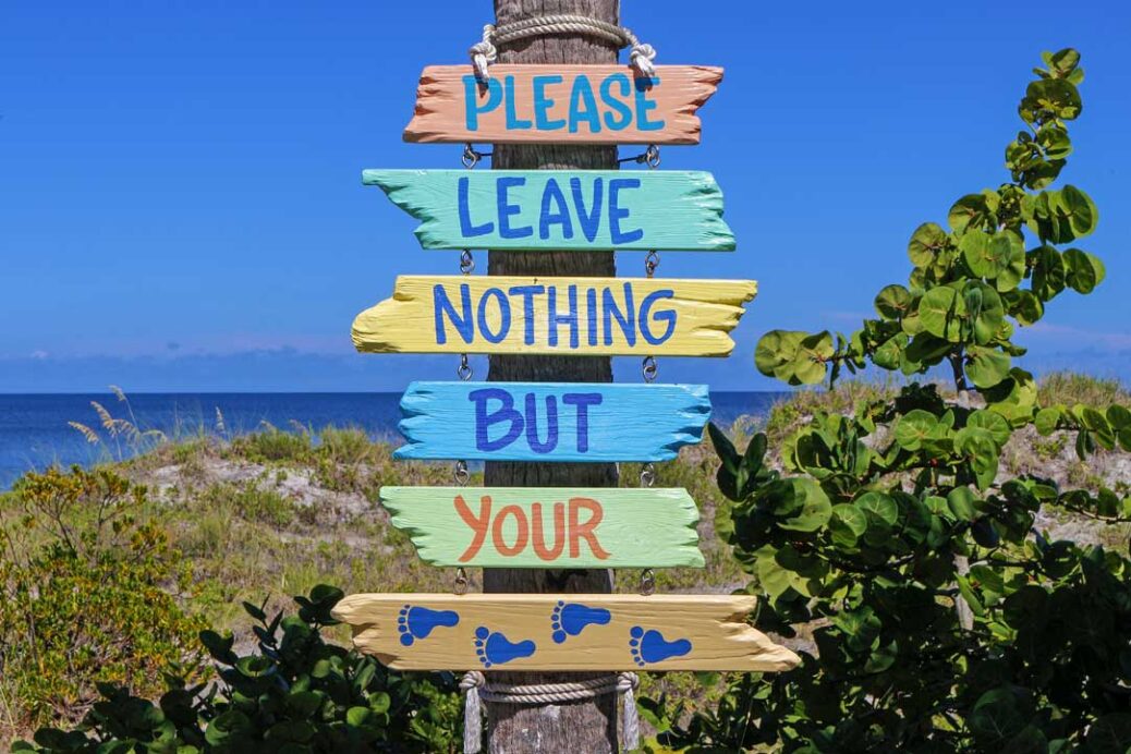Sign at the beach saying 'Please leave nothing but your footprints'