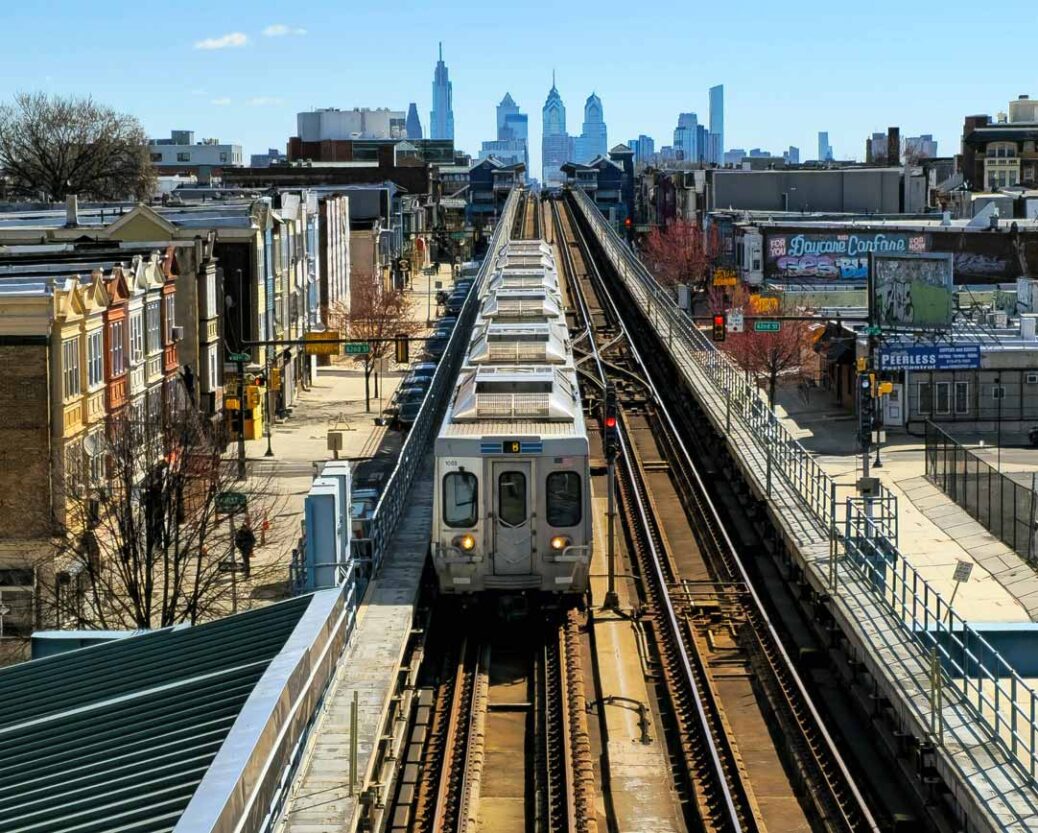 Septa train at 63rd street station on the Market-Frankford line with city skyline behind Philadelphia Pennsylvania USA
