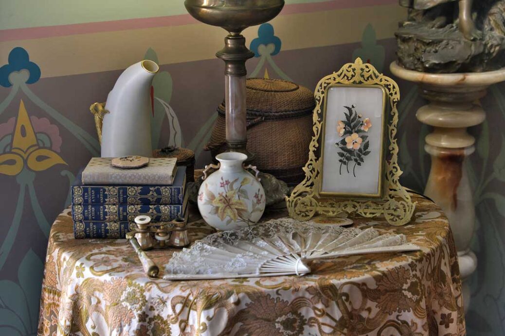 Victorian era ornaments, books and fan on sidetable at Ebenezer Maxwell Mansion Philadelphia
