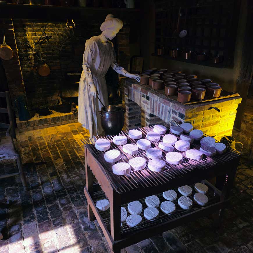 Exhibit showing figure of woman making the cheese at the Camembert museum in Camembert Normandy France