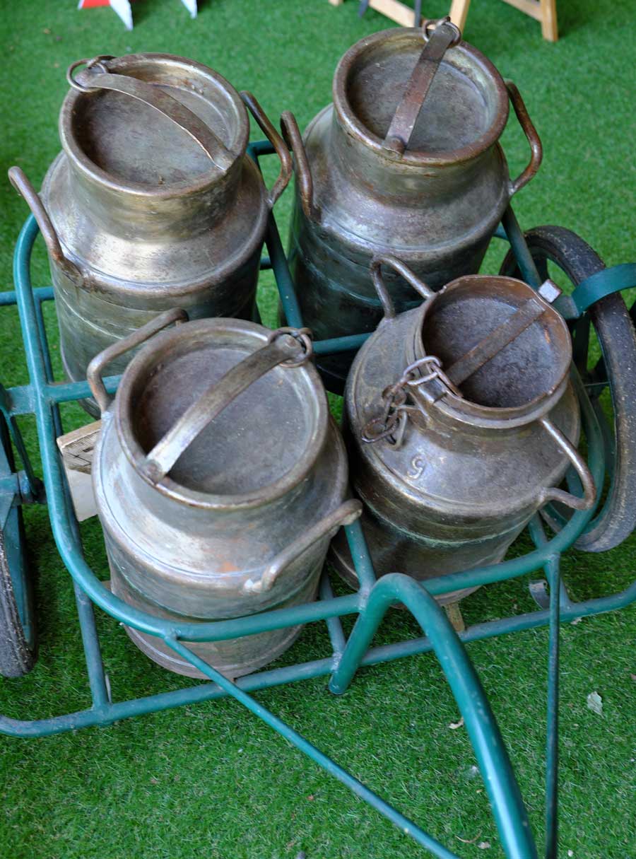 4 metal milk churns in a cart at the Camembert Museum Vimoutiers