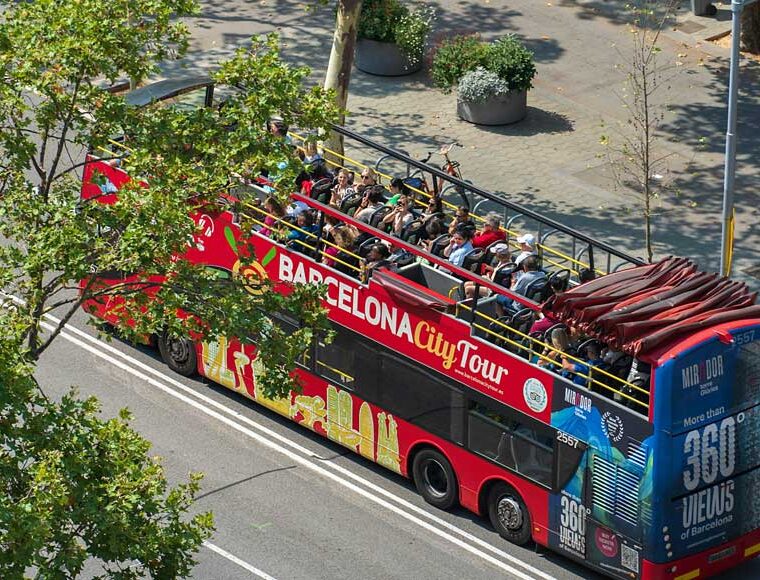Red open-top Barcelona tour bus with passengers