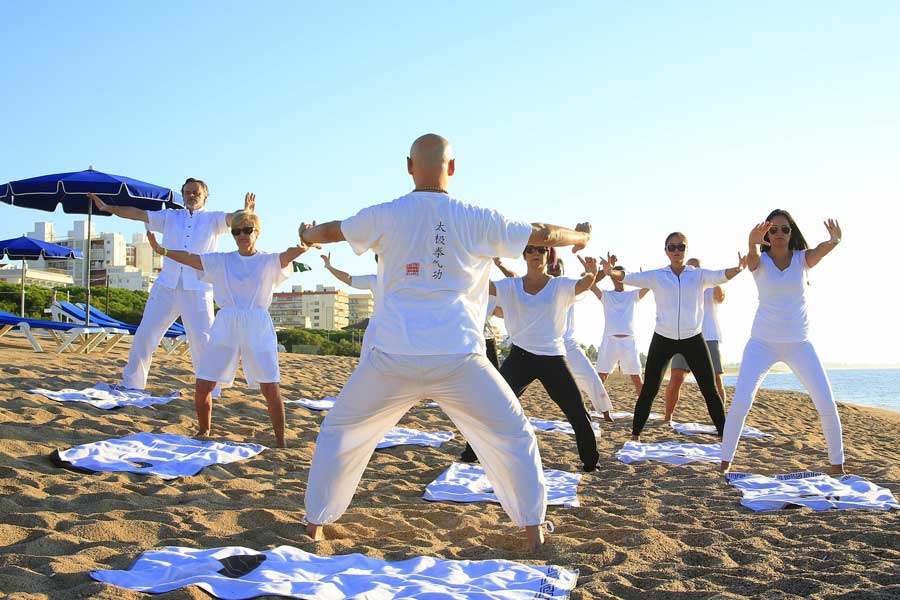 People practising yoga on the beach