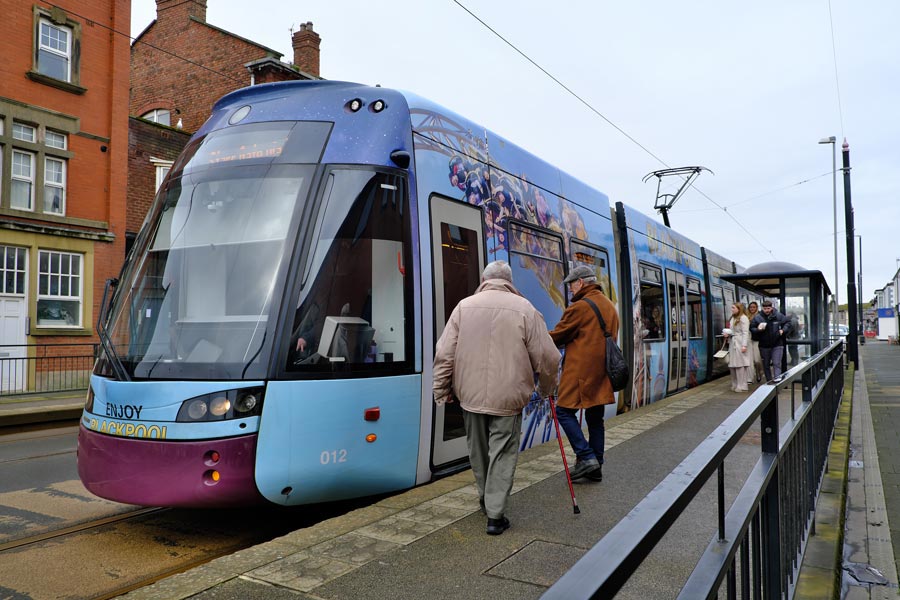 Passengers boarding a blue Blackpool tram at Fleetwood