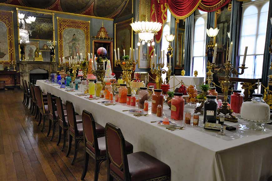 Banqueting table with jars of coloured pigments and replica food at Royal Pavilion Brighton