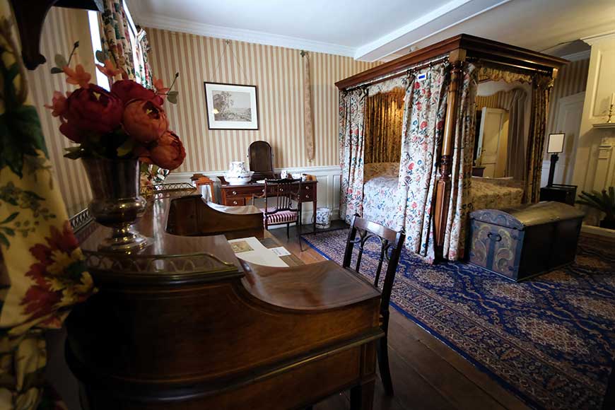 Lady Ellen Thomas-Stanford's bedroom with four poster bed, wash stand, and desk at Preston Manor, Brighton