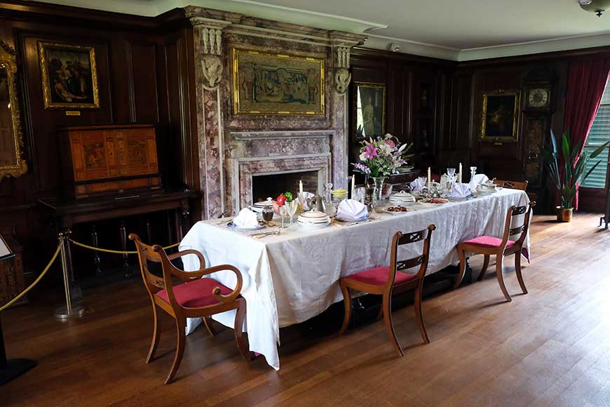 Table laid for Edwardian breakfast in front of ornate fireplace in the dining room at Preston Manor, Brighton